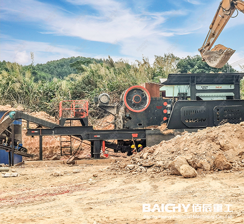 Mobile jaw crusher station crushing limestone in quarry.jpg